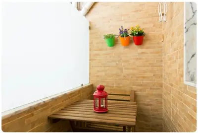 a red lantern sitting on a wooden bench with potted plants at Porto Village Inn in Porto
