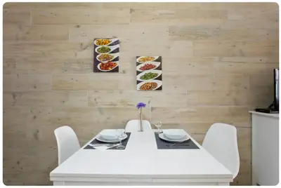 a white table with chairs and plates of food on a wall at Porto Village Inn in Porto