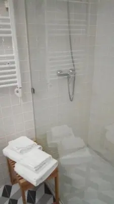 a bathroom with a shower with a toilet and towels at Oporto City View - Wonderful Apartment in Porto