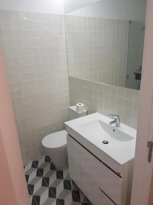 a bathroom with a sink and a toilet and a mirror at Oporto City View - Wonderful Apartment in Porto