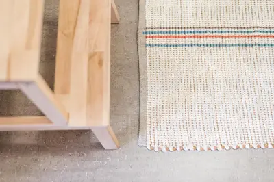 a rug on the floor next to a wooden table at SOBRI Cork House - Sustainable Loft in Porto