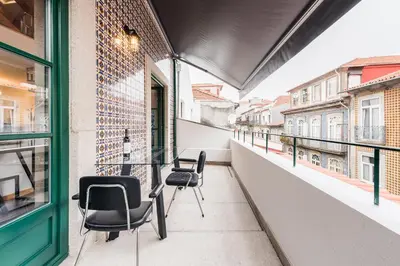 a balcony with chairs and a table on a building at SOBRI Cork House - Sustainable Loft in Porto