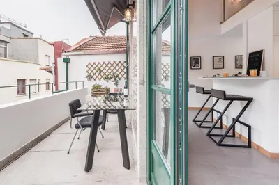 a balcony with a table and chairs on a building at SOBRI Cork House - Sustainable Loft in Porto