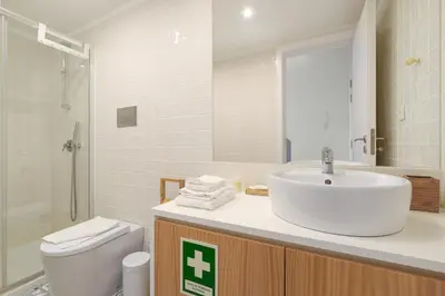 a bathroom with a sink and a shower and a toilet at Skylight Apartment in Porto