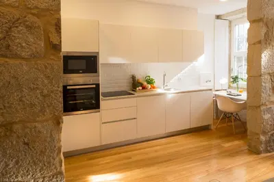 a kitchen with white cabinets and a counter top at Aposentus - Your fabulous home next to Ribeira in Porto