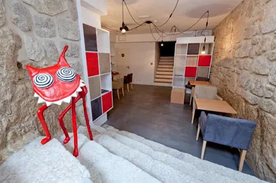 a room with a red cat statue on the wall at InPatio Guest House in Porto