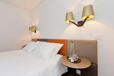 a bedroom with a bed with a table and two lamps at InPatio Guest House in Porto