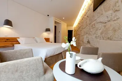 a hotel room with two beds and a table and chairs at InPatio Guest House in Porto