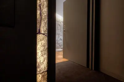 an open door to a room with a stone wall at InPatio Guest House in Porto