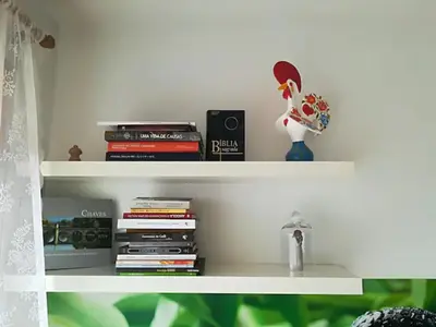 a book shelf with books and a stack of books at Apartamento Praça - Vistas sobre a cidade in Porto