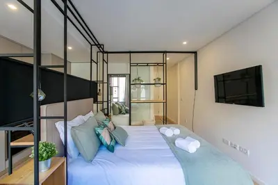 a bedroom with a large bed with blue pillows at Chillout Trindade Apartment in Porto