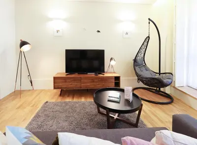 a living room with a chair and a television at HM - Ribeira São João 1B in Porto