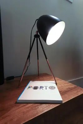 a black lamp sitting on top of a wooden table at HM - Ribeira São João 1B in Porto