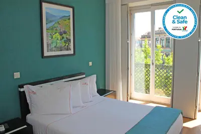 a bedroom with a bed and a large window at Vivacity Porto - Rooms & Apartments in Porto