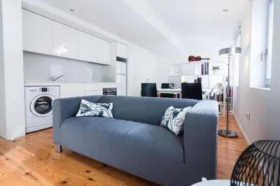 a living room with a blue couch and a kitchen at ON Apartments - Violin in Porto
