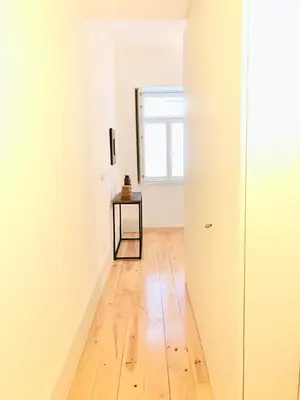 a hallway with a table and a window at Lóios Flat in Porto