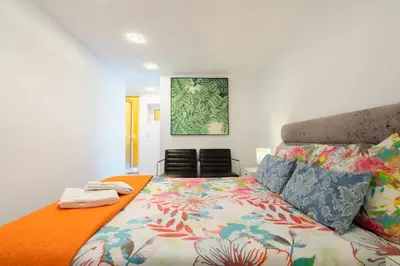 a bedroom with a bed with an orange bedspread at Central Apartamento 0 AC Metro Nearby in Porto