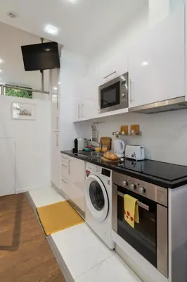 a kitchen with a stove and a washing machine at Central Apartamento 0 AC Metro Nearby in Porto