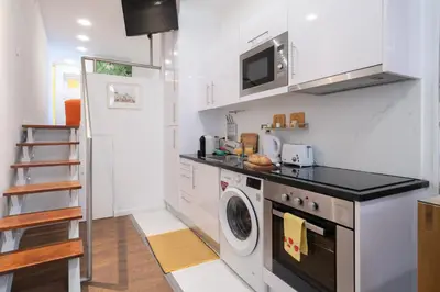 a kitchen with a washing machine and a microwave at Central Apartamento 0 AC Metro Nearby in Porto