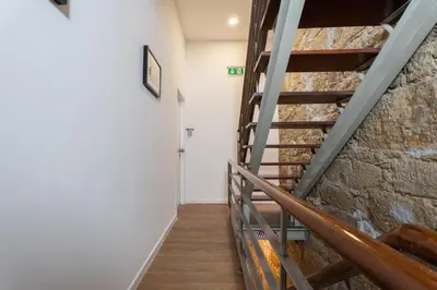 a staircase in a room with a stone wall at Central Cozy Stay 2 AC Near Metro in Porto
