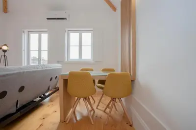 a bedroom with a bed and a table and chairs at Liiiving in Porto | Historic & Sunny Terrace in Porto
