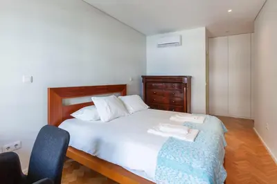 a bedroom with a white bed and two chairs at Go2oporto @Ceuta in Porto