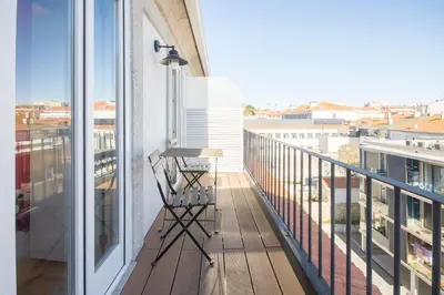a balcony with a table and a view of a city at Loft D. João IV in Porto