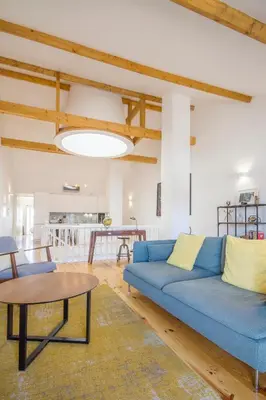a living room with a blue couch and a table at Loft D. João IV in Porto