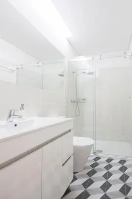 a white bathroom with a sink and a shower at Loft D. João IV in Porto