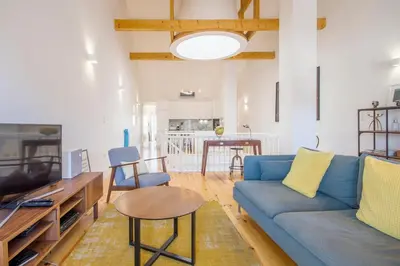 a living room with a blue couch and a table at Loft D. João IV in Porto