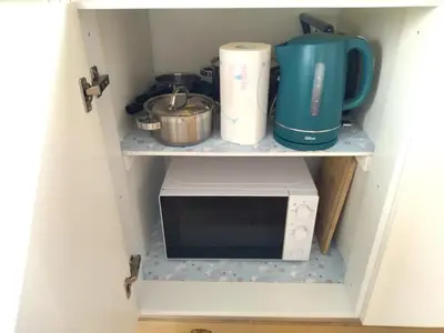 a kitchen with a microwave and a coffee maker on a shelf at Santa Catarina Patio Apartment - with washer machine in Porto