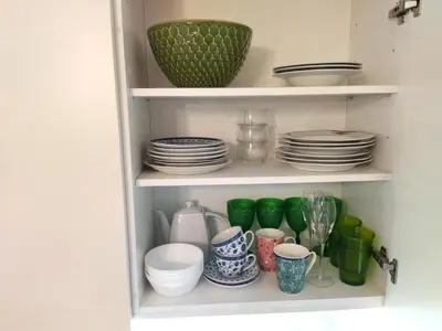 a cupboard filled with plates and bowls and dishes at Santa Catarina Patio Apartment - with washer machine in Porto