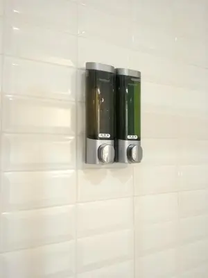 a shelf in a bathroom with black and green bottles at Santa Catarina Patio Apartment - with washer machine in Porto