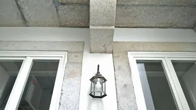 a lamp on the side of a building with two windows at Santa Catarina Patio Apartment - with washer machine in Porto