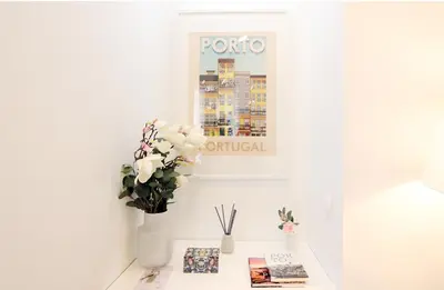 a white table with a vase of flowers and books at HM - OPorto City View in Porto