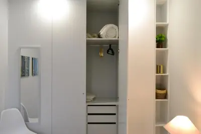 a white closet with white shelves in a room at Downtown Porto Spot in Porto