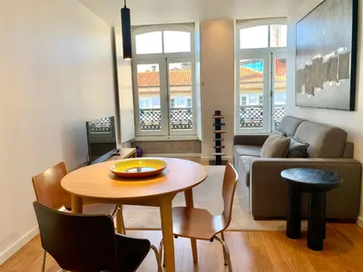 a living room with a table and a couch at RIBEIRA OPORTO APARTMENT (NEW) in Porto