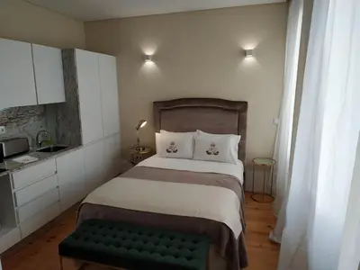 a small bedroom with a bed and a green bench at ML Apartments Republic in Porto