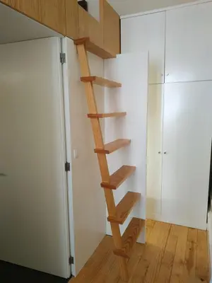 a wooden spiral staircase in a room with a closet at ML Apartments River in Porto