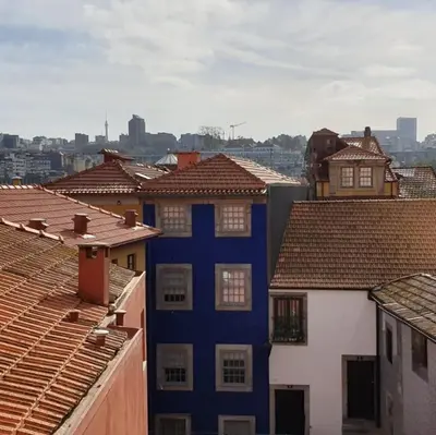 a blue building in the middle of a group of roofs at Lux Ribeira - ALL INCLUDED in Porto