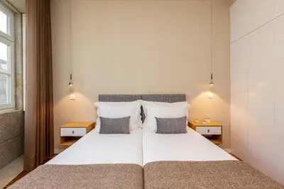 a bedroom with a large white bed with two pillows at RS Porto Historic Center in Porto