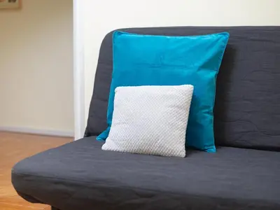 a blue pillow sitting on top of a couch at Oporto Guest Alegria Flat Downtown in Porto