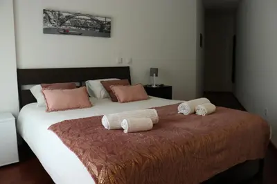 a bedroom with a large bed with two pillows on it at Metro Heroismo Residence in Porto
