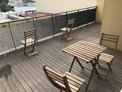 two chairs and a wooden table and chairs on a balcony at Metro Heroismo Residence in Porto