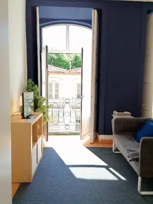 a living room with a door open to a balcony at Downtown Porto Spot - 2 bedrooms in Porto