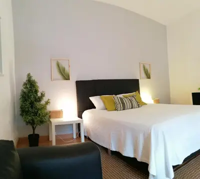 a bedroom with a large bed and a chair at Downtown Porto Spot - 2 bedrooms in Porto