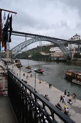 a bridge over a river with people on the beach at Apartamentos sobre o Douro in Porto