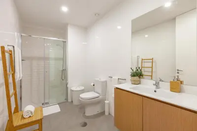 a white bathroom with a toilet and a sink at Oporto Palace Apartments in Porto