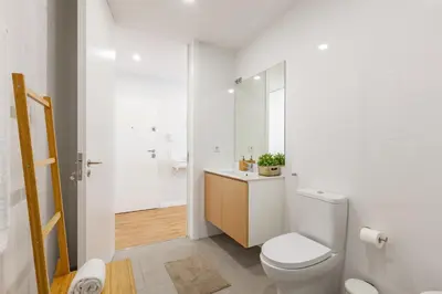 a white bathroom with a toilet and a sink at Oporto Palace Apartments in Porto