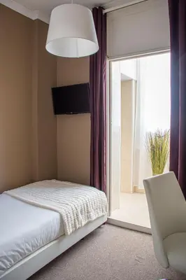 a bedroom with a bed and a chair and a window at O'Porto Seven - Guest House in Porto